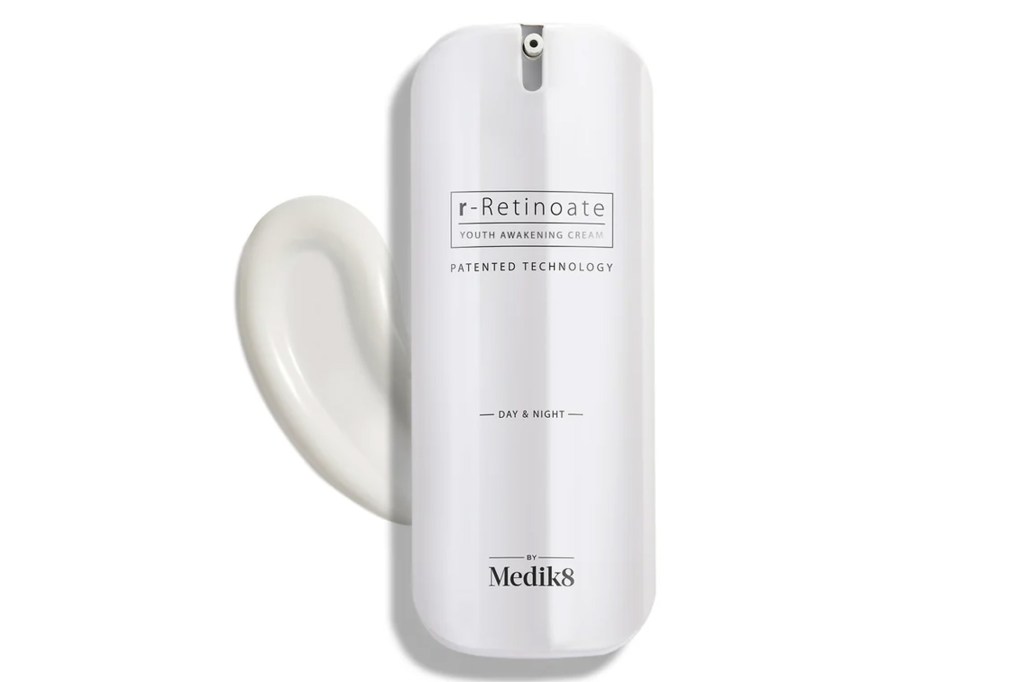 Medik8 r-Retinoate Youth Awakening Cream in a white bottle with a dollop of cream beside it.