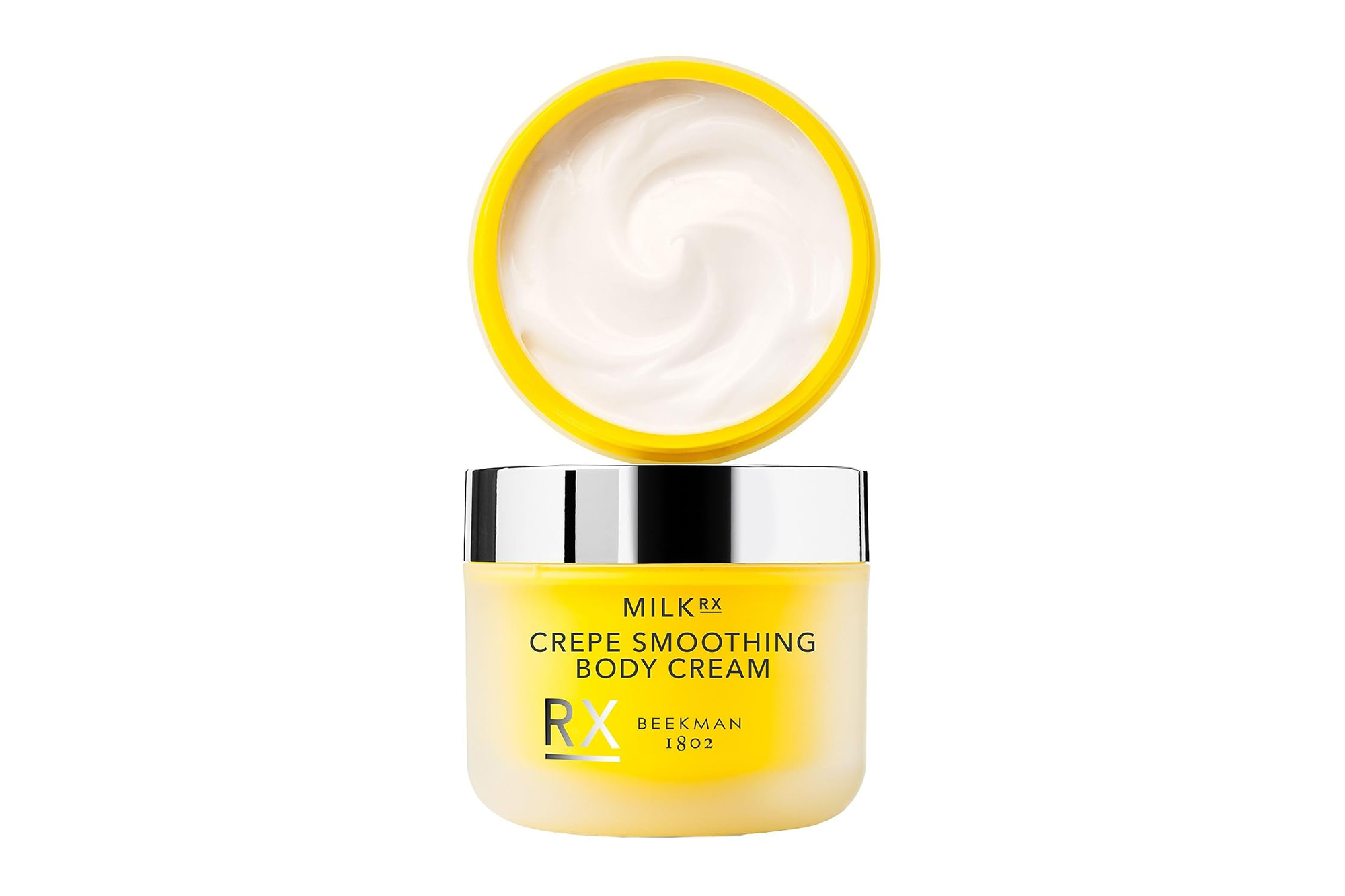 Beekman 1802 Milk RX Crepe Smoothing Body Cream in a yellow jar with its lid upside down next to it, revealing the white cream inside.