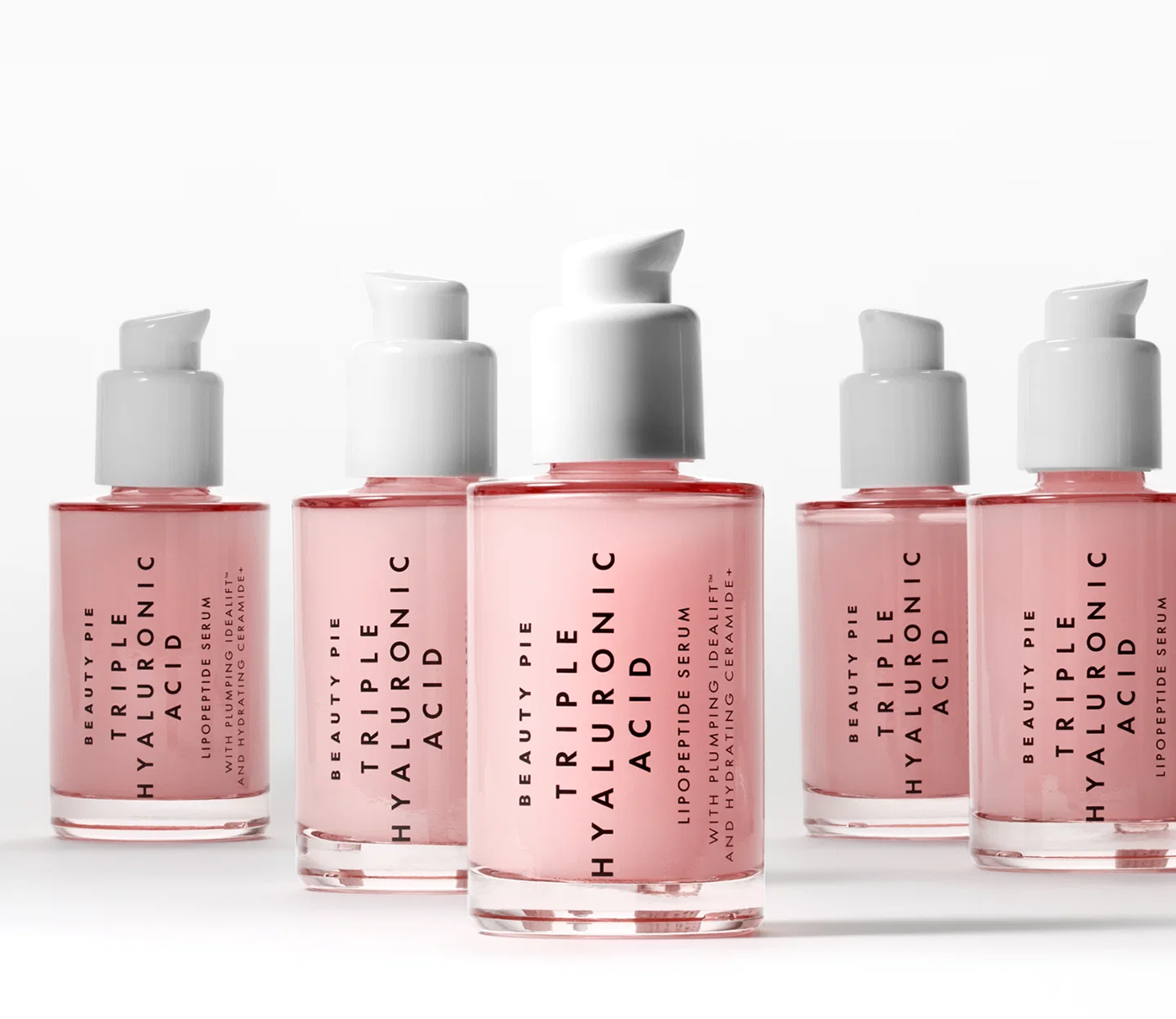 Five bottles of Beauty Pie Triple Hyaluronic Acid Lipopeptide Serum arranged on a white surface.
